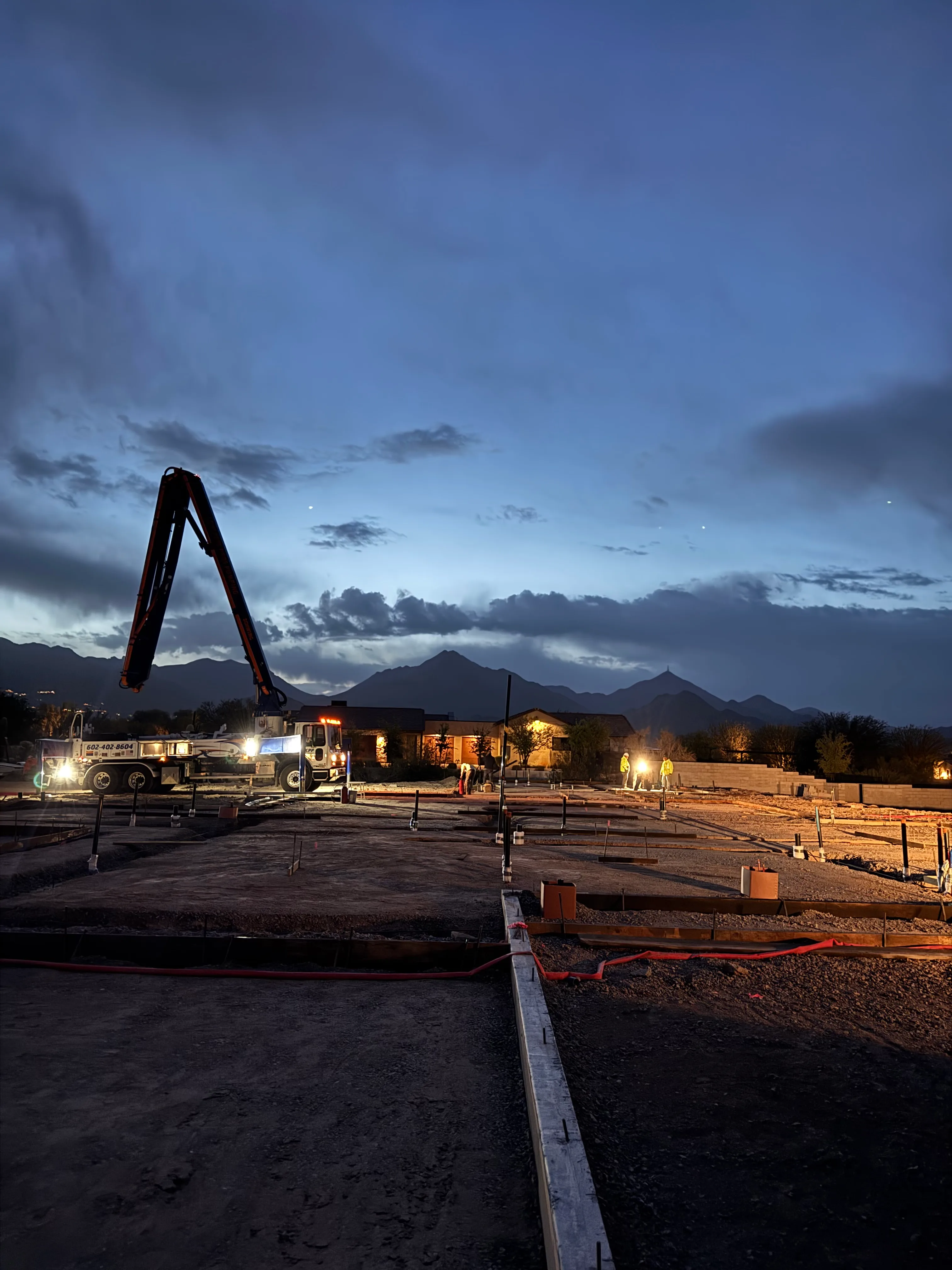 Valley Con night concrete pour with pump truck and Arizona mountains